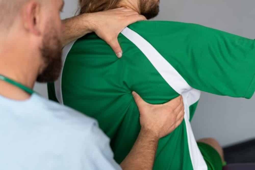 paciente camiseta verde siendo tratado por terapeuta