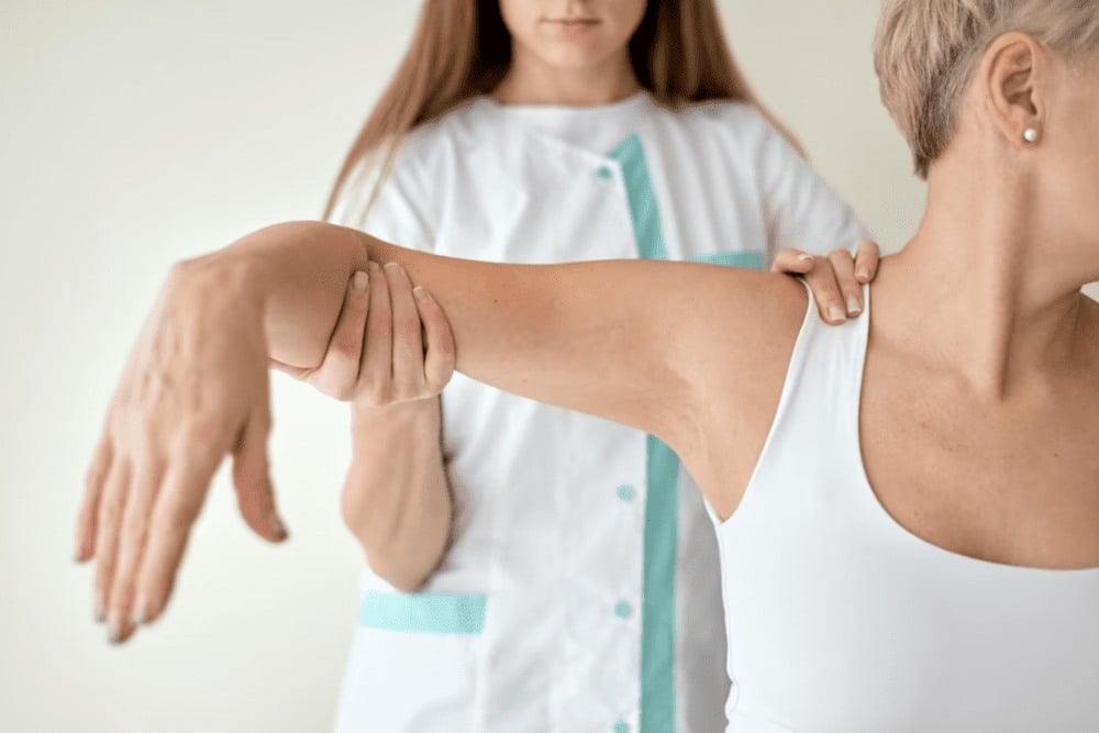 profesional terapéutico tratando dolencia brazo paciente